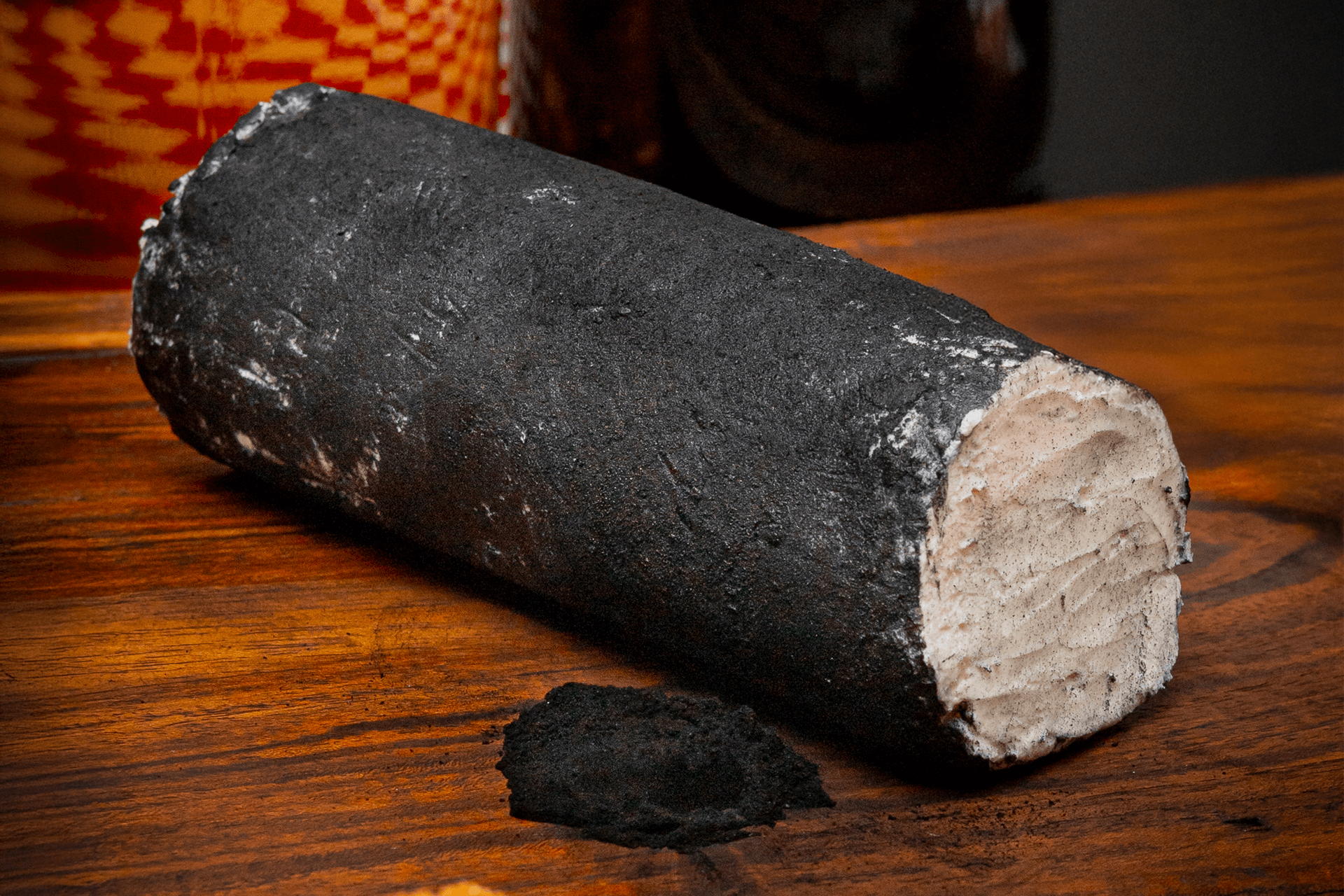 Rulo completo de queso de cabra Le Blanc con ceniza vegetal listo para ser degustado, enfatizando su apariencia artesanal y sofisticada.