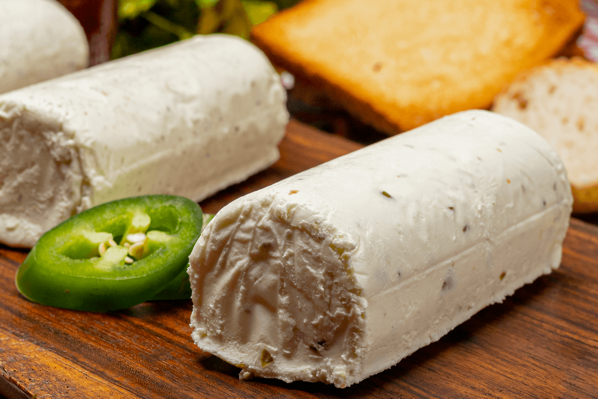 Rulo completo de queso de cabra Le Blanc con jalapeño preparado para el servicio, destacando su apariencia apetitosa y la calidad de su elaboración.