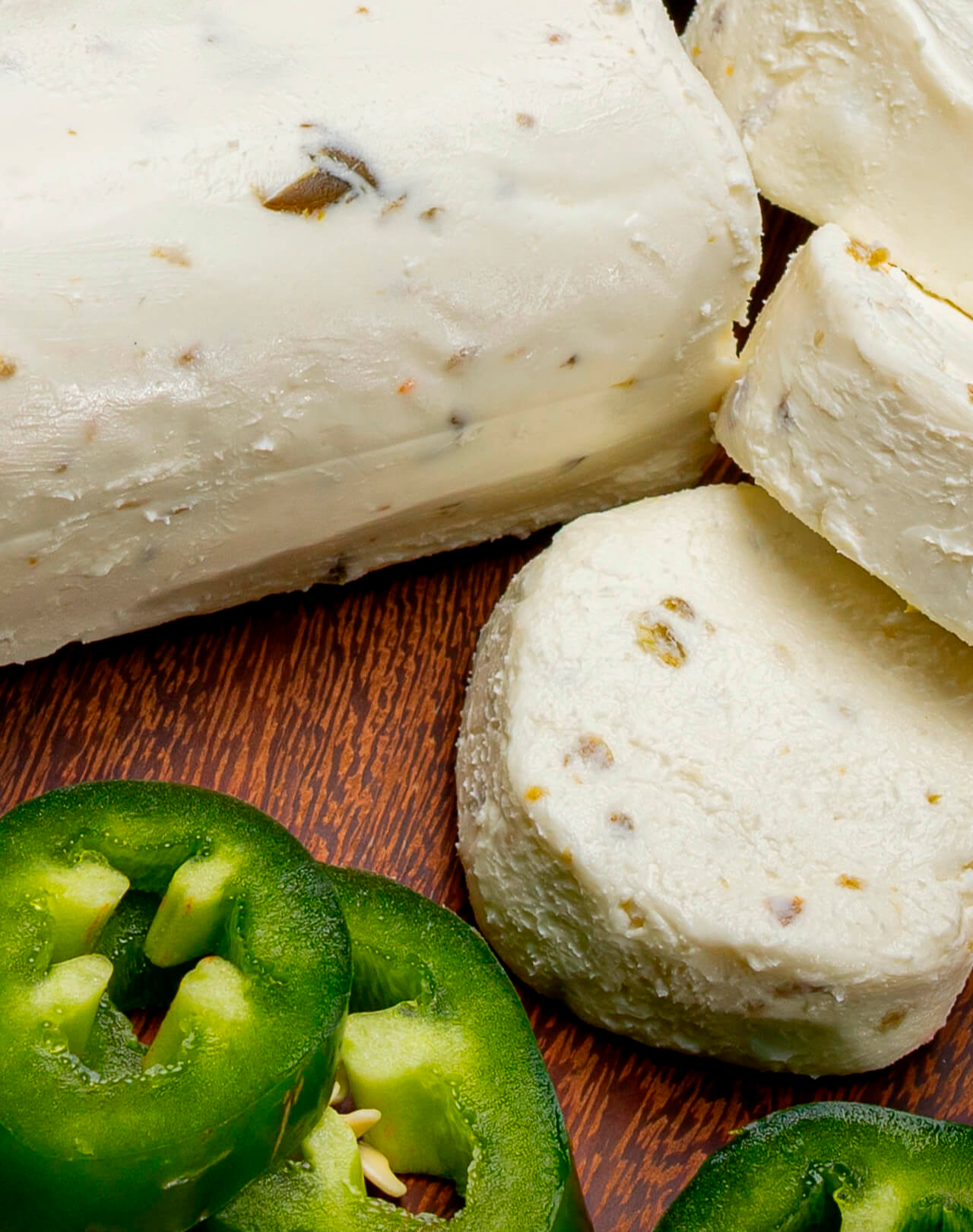 Primer plano de queso de cabra Le Blanc con trozos de chile, representando el puente entre la técnica francesa de maduración y los ingredientes selectos de la gastronomía mexicana.